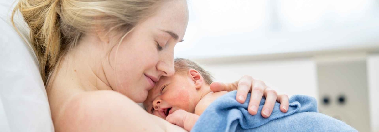 Geburtstrauma verarbeiten - Mutter mit neu geborenem Baby auf ihrer Brust