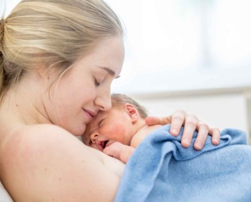 Geburtstrauma verarbeiten - Mutter mit neu geborenem Baby auf ihrer Brust