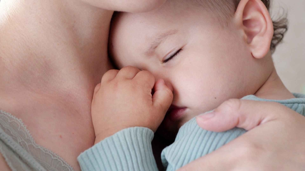 Mutter mit Baby Ein Baby schläft auf Mamas Arm