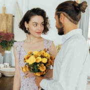 Ein Mann überreicht einer Frau gelbe Blumen