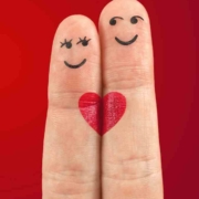 zwei Finger, die mit Gesichtern und einem Herz bemalt sind