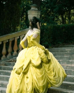 Goldenes Kleid als Märchen-Symbol: Eine Prinzessin mit einem goldenen Kleid geht die Schlosstreppe hinauf.