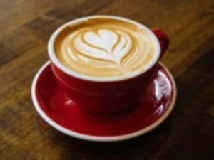 Eine Tasse Kaffee mit Herzen aus Milchschaum.